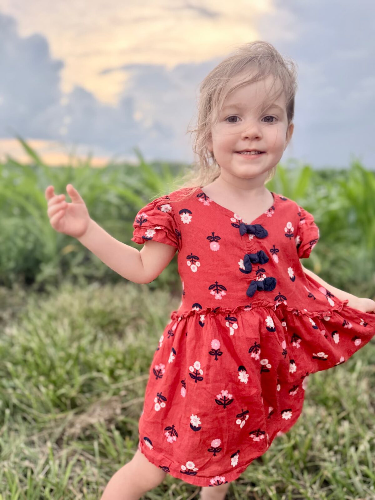 A Kassab daughter twirling in a field at sunset